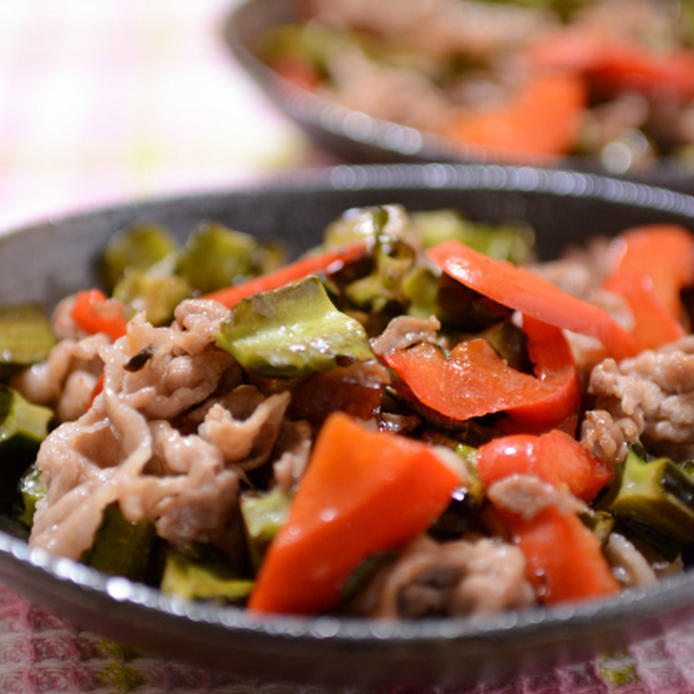 黒い丸皿に盛られた豚肉と四角豆の中華炒め