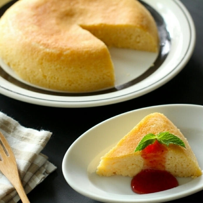 ラインが入った丸皿に盛られた米粉チーズケーキと、楕円の白皿に盛られたソースつきの米粉チーズケーキ