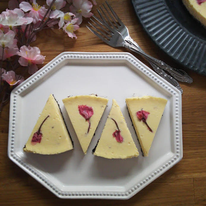 グレーの皿に盛られた桜の塩漬けのチーズケーキ