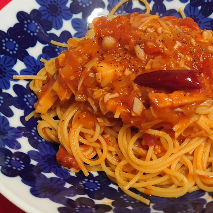 青い皿に盛られたアンチョビとえのきのトマトパスタ