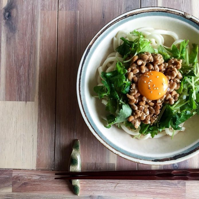 縁のある皿に盛られている納豆と三つ葉のごま油うどん