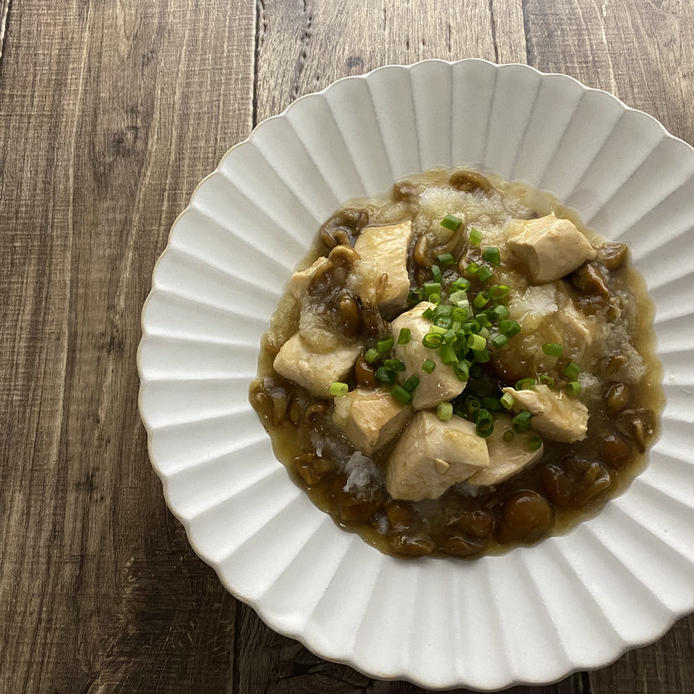 白い花形の皿に盛られている鶏むね肉となめこのみぞれ煮