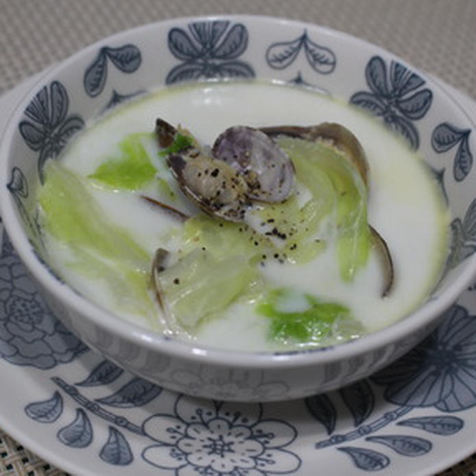 紺の花柄模様の器に盛られている、あさりとキャベツの牛乳スープ