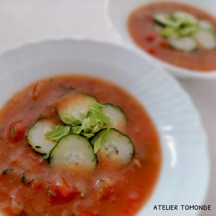 白い器に盛られた、セロリの葉ときゅうりをトッピングした冷製トマトスープ