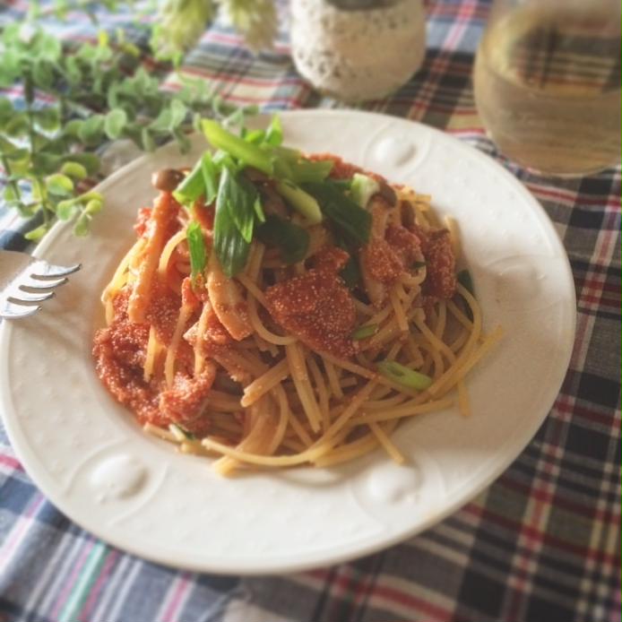 白い丸皿に盛り付けられた明太子としめじのにんにくトマトパスタ