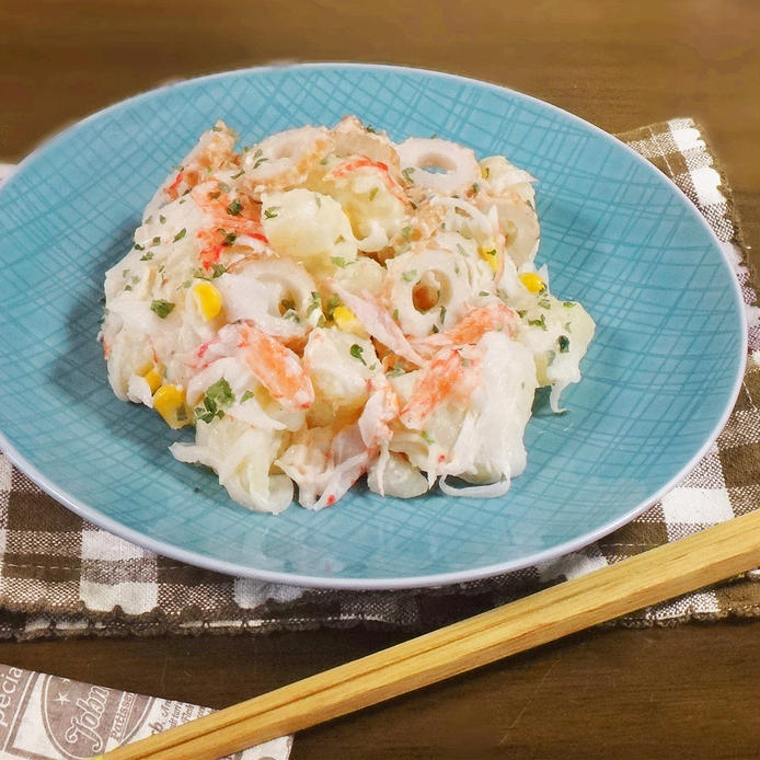 水色の皿に盛りつけられたほぼカニとちくわ入りのポテトサラダ