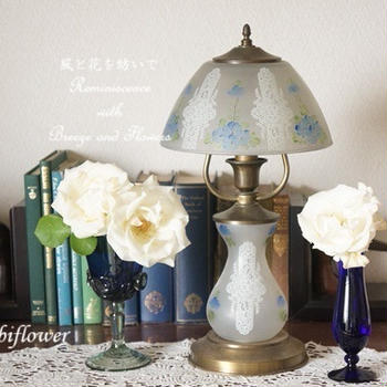 ベランダの白い薔薇を青いグラスに