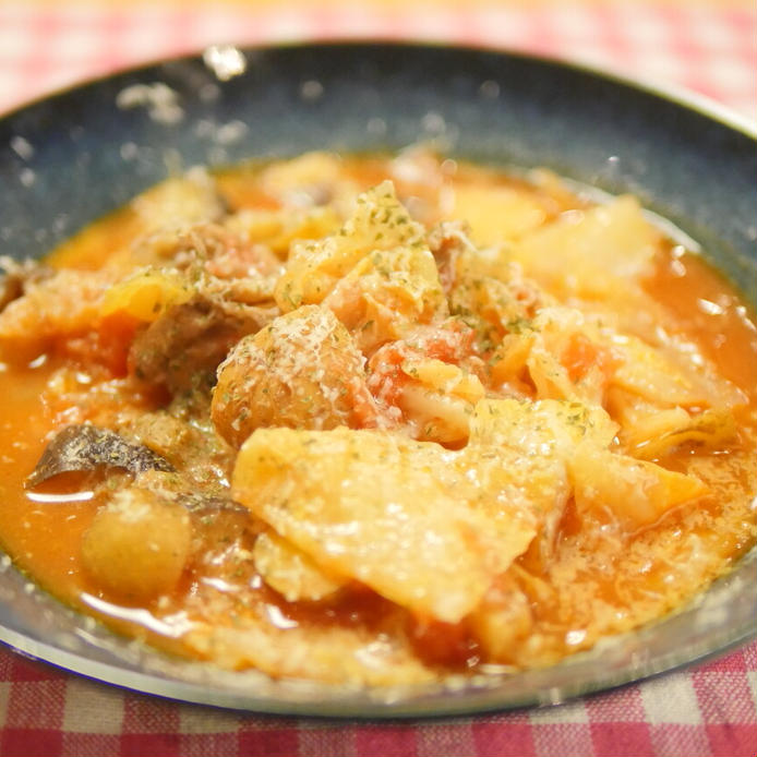 お皿に盛られた豚肉とキャベツのトマトスープ