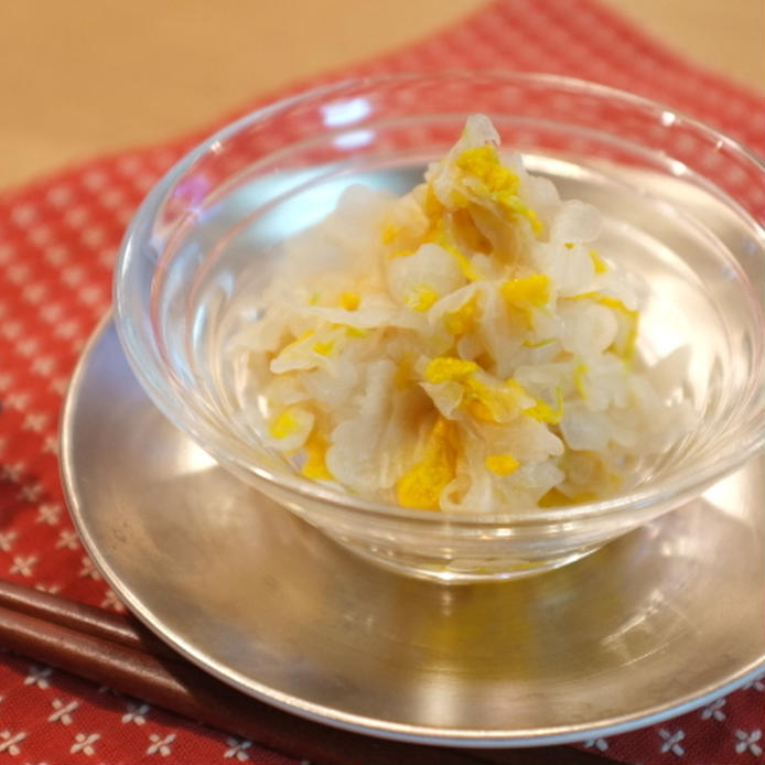 ソーサー付きガラス小鉢に盛りつけられた白ゴーヤと食用菊の甘酢和え