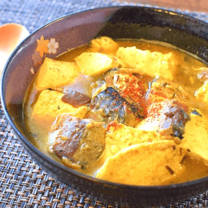 陶器の器に盛り付けたサバ味噌缶と豆腐のバターカレー煮込み