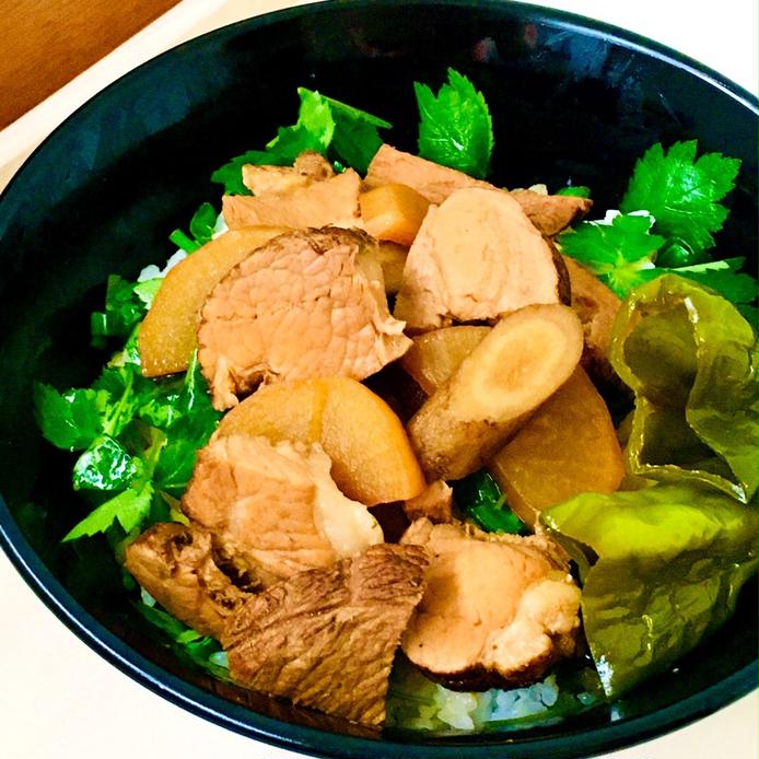 黒い皿に盛られた野菜と豚肉のチャーシュー