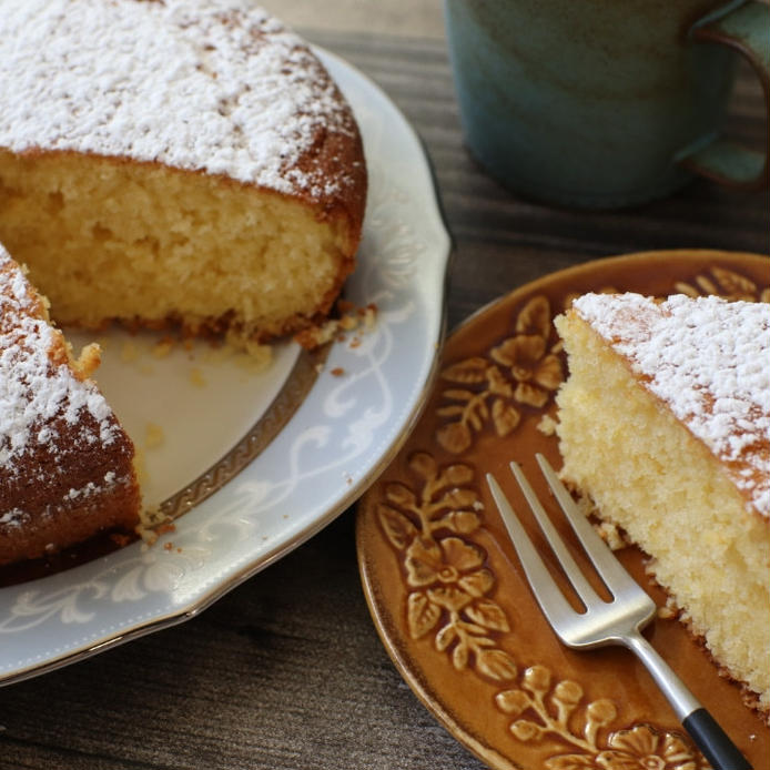 ふちに飾りのある茶色い皿に盛りつけた、カットしたレモンパウンドケーキ