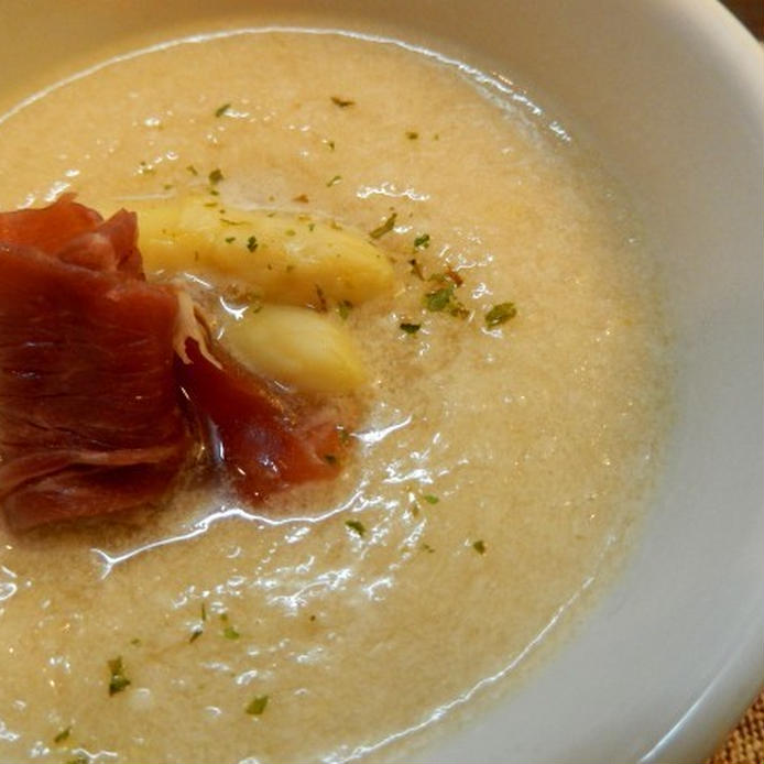 白いスープ皿に盛られたホワイトアスパラガスと生ハムのスープ