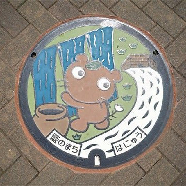 埼玉県羽生市のカラーマンホールは「ムジナもん」と「藍染」がデザインされています