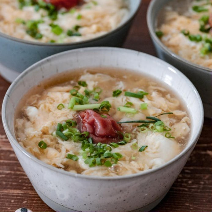 グレーの丼に盛られている梅干しと卵のあんかけうどん