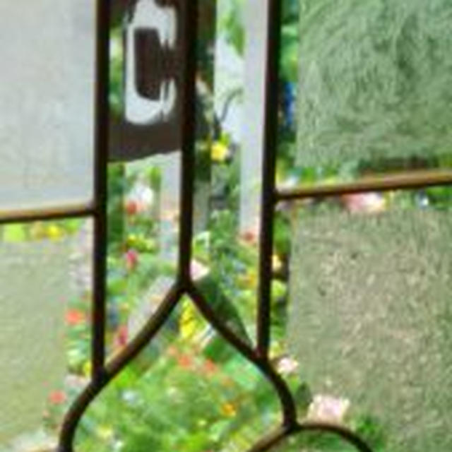 玄関の窓ガラスを通して見える花壇にいやされます