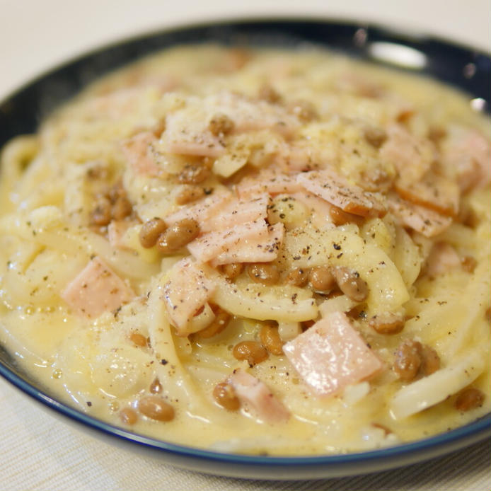 丸いお皿に盛られたネバネバカルボナーラうどん