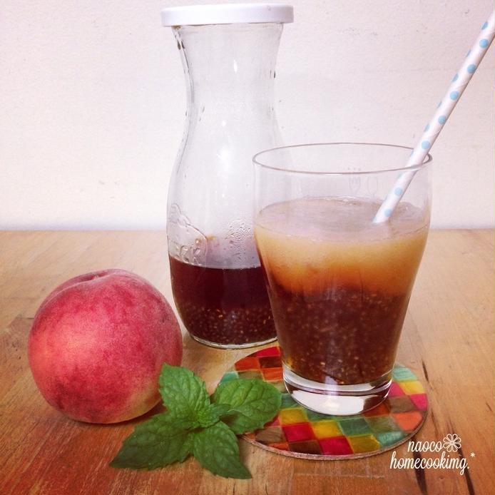 透明グラスに入ったチアシード入り桃のアイスティーと桃、ピッチャー