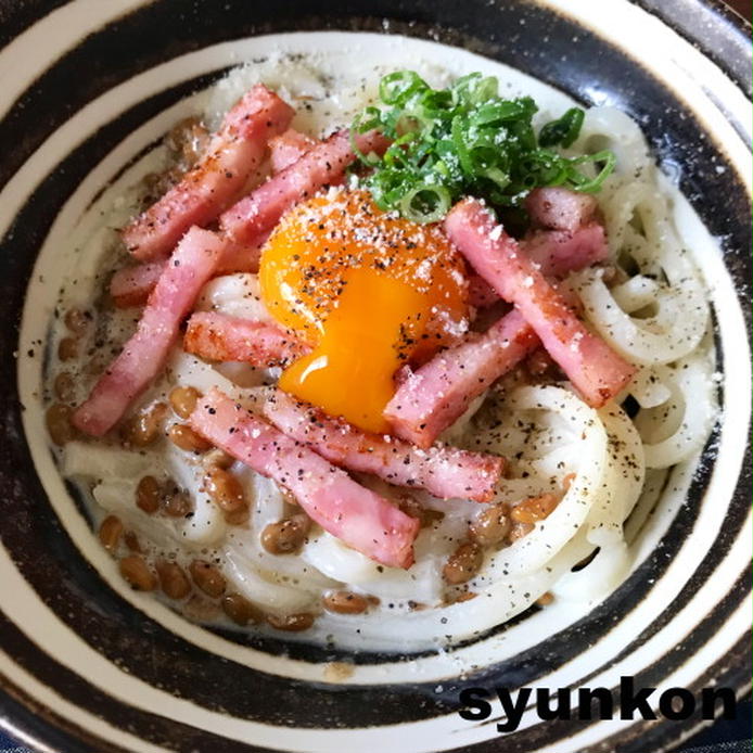 白と黒の器に盛られている納豆カルボナーラうどん