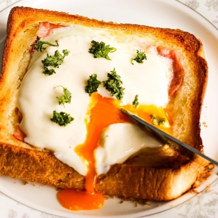 エッグベネディクト風トーストの卵をナイフで割る様子