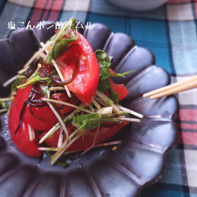黒い皿に盛られた水菜とトマトの塩昆布ナムル