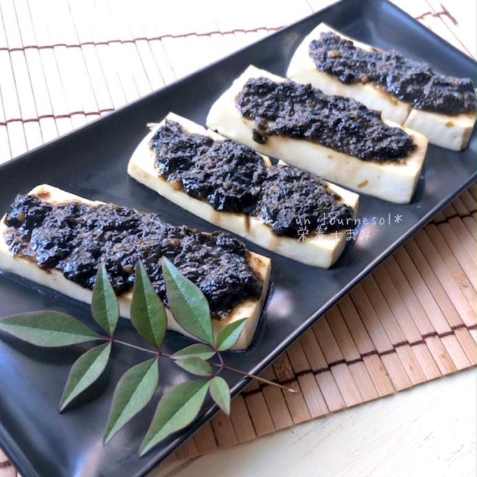 黒い長皿に盛りつけられている海苔ソースの豆腐田楽風