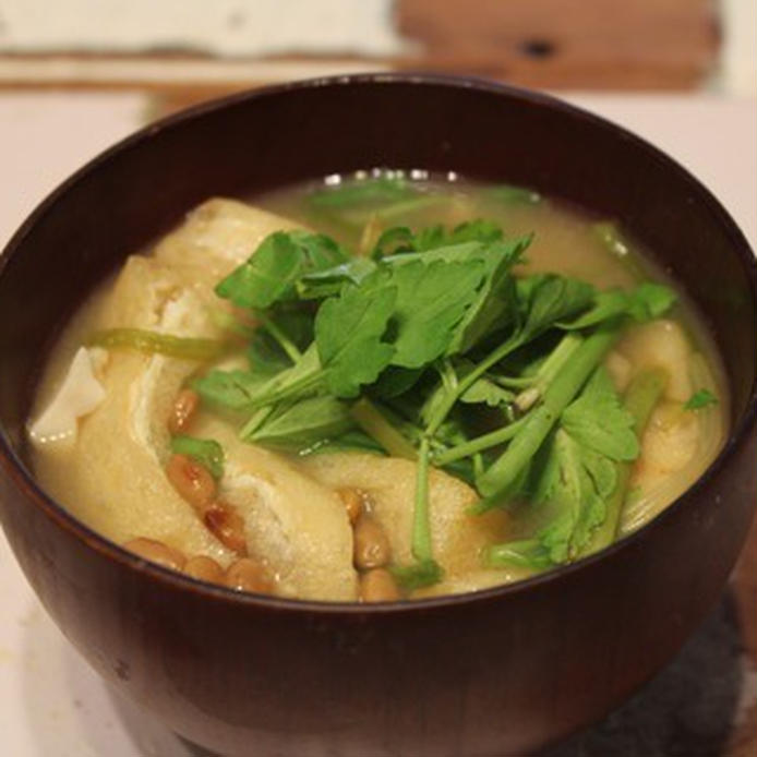 木のお椀に入っているせりと油揚げ、豆腐や納豆入りのみそ汁