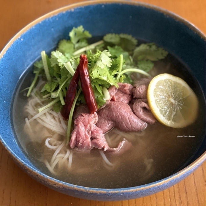 青い丼に盛り付けた薄切り牛肉のフォー