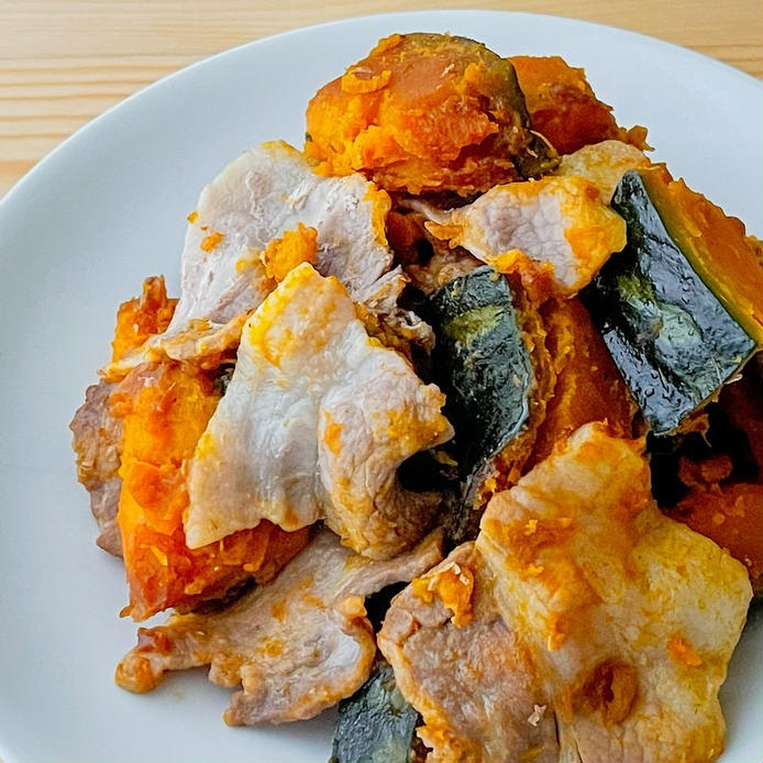 白い皿に入ったかぼちゃと豚バラ肉の甘辛煮