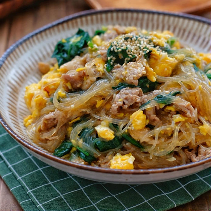 ベージュの皿にのった豚バラ肉とほうれん草と卵の春雨煮