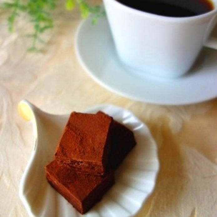 白い皿に盛られてコーヒーがそえられた豆腐の生チョコレート