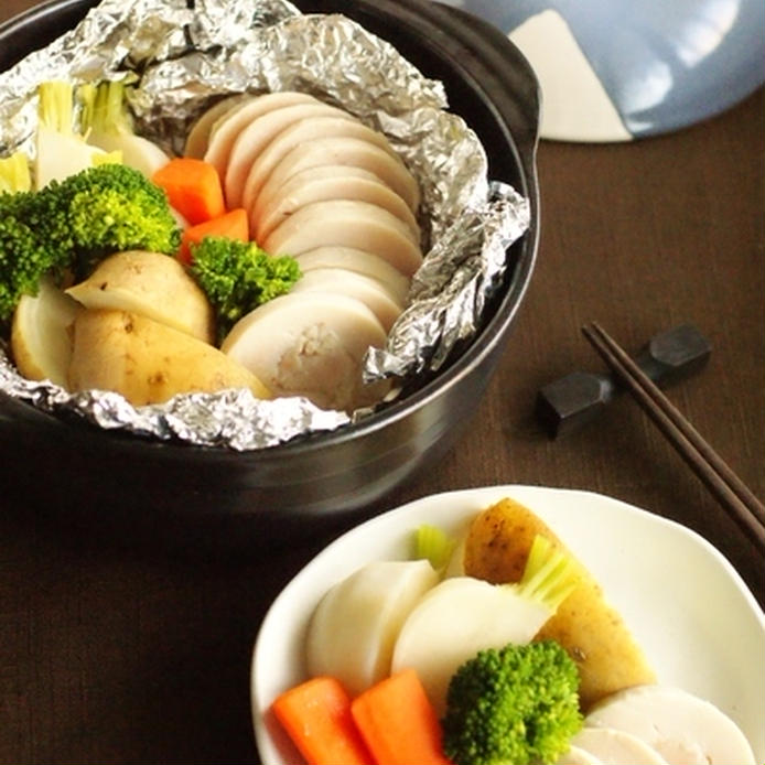 土鍋と白い取り分け皿に盛り付けた鶏ハム野菜の温サラダ