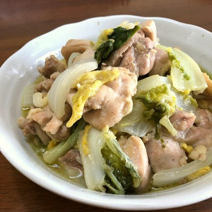 白い丸皿に盛られた鶏もも肉と白菜の炒め煮