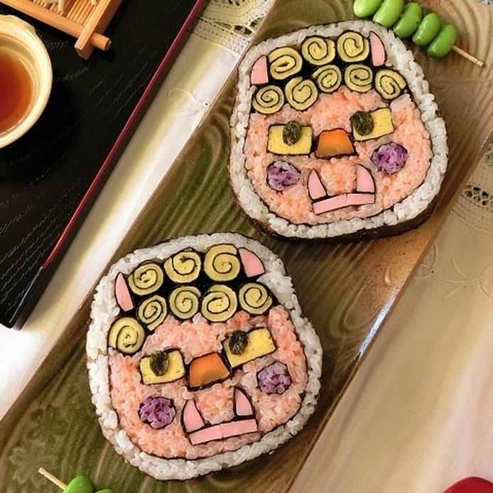 木の皿に並べられた鬼の飾り巻き寿司