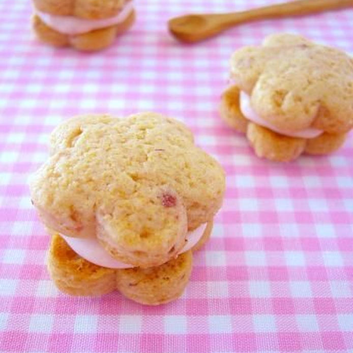 ピンクのギンガムチェックの布の上に置いたいちごジャム＆クリームチーズの桃の花サンドクッキー
