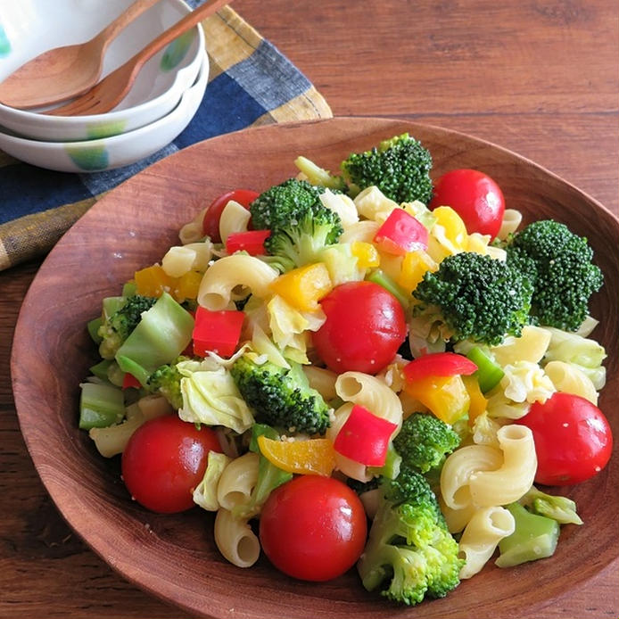 木の器に盛られたカラフルな野菜とマカロニのソテー