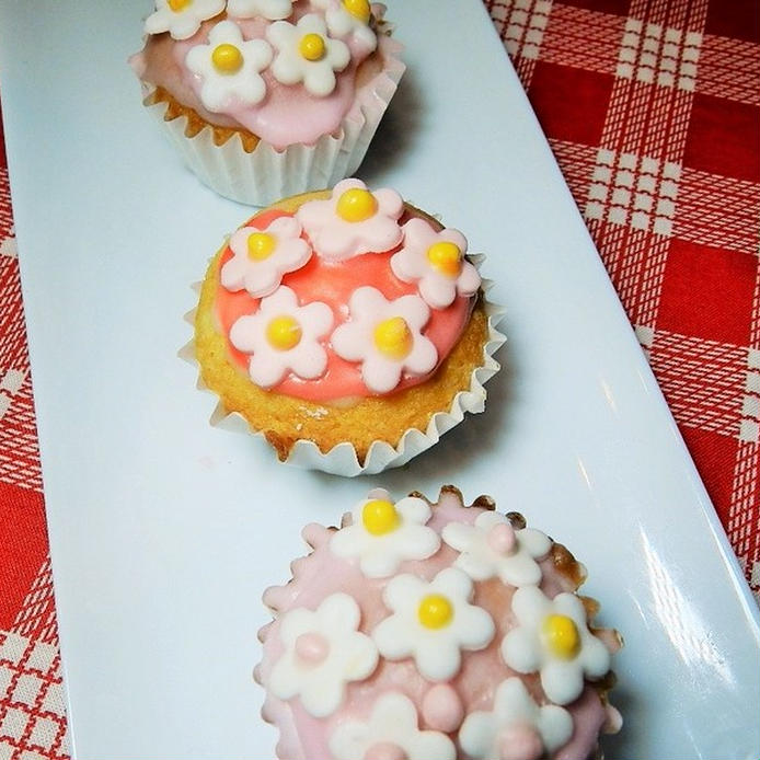お皿にのった小花柄のマシュマロフォンダントでデコレーションされたカップケーキ