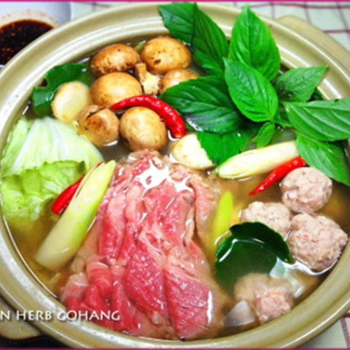 鍋に入った、唐辛子やハーブを散らした白菜と牛肉のタイ風鍋