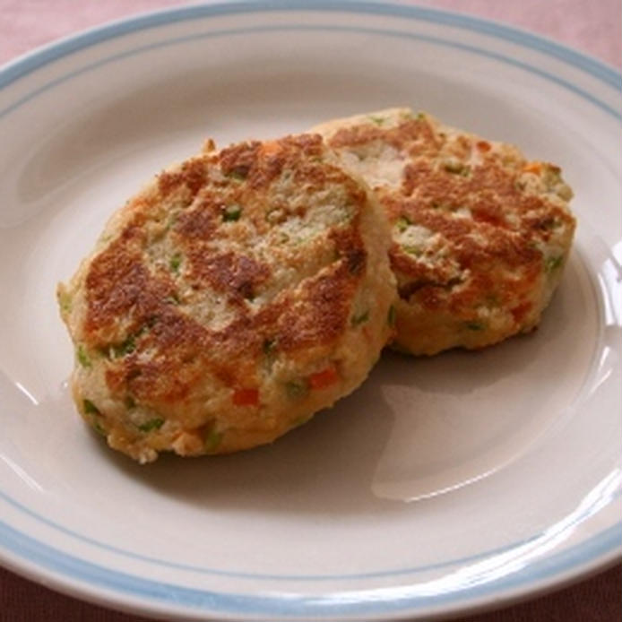 ふちが水色の白い皿に野菜のおからハンバーグが2つ盛り付けられている