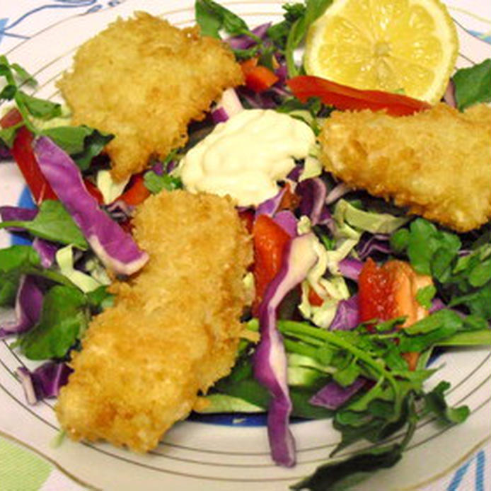 丸皿にサラダと白身魚のフライが盛られている