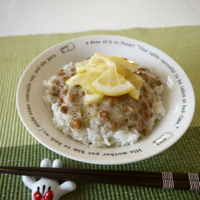 白い皿に盛り付けられた納豆ごはんに、レモンスライスがトッピングされている