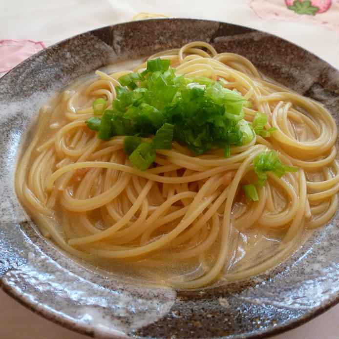 茶色い器に盛ったきざみ葱がのったスープパスタ