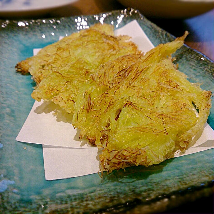 青色の和皿に紙をしいて盛られたヤングコーンのひげ天ぷら